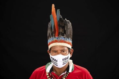 El líder indígena José Augusto, de 48 años, del grupo étnico indígena miranha, vestido al modo tradicional, posa en la comunidad del Parque de las Naciones Indígenas en Manaos, Brasil, el jueves 28 de mayo de 2020. En su máscara se lee, en portugués: "Las vidas indígenas importan".