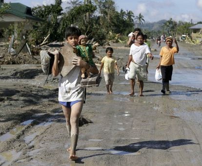 Varios de los evacuados caminan de regreso al centro despu&eacute;s de recuperar sus enseres personales. 