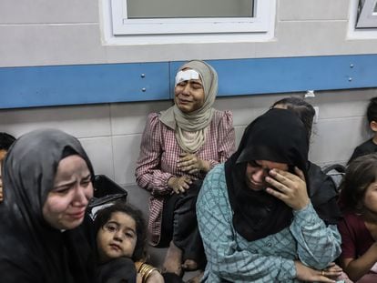 Mujeres y niños en el hospital Al Ahli tras el bombardeo que mató a cientos de personas en el recinto del centro médico, este martes.