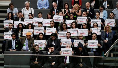 Miembros de la comunidad armenia en Alemania sostienen carteles en los que se lee "gracias" durante la votación en el Bundestag.