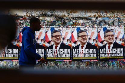 Un hombre pasa frente a los carteles electorales de Jean Luc Mélenchon en París.