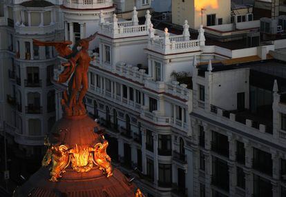 La Victoria alada, sobre el edificio Metrópolis, en Gran Vía con la calle de Alcalá, recibe los primeros rayos del sol.