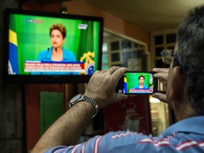 Un hombre graba en Brasil un discurso televisado de Roussef.
