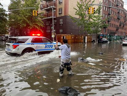 A man works to clear a drain in flood waters, Friday, Sept. 29, 2023, in the Brooklyn borough of New York