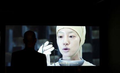 Un hombre mira la película 'News from Nowhere. El fin del mundo 2012' de los artistas coreanos Moon Kyungwon y Jeon Joonho en documenta.