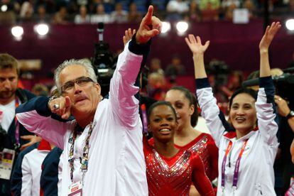 El entrenador del equipo femenino de gimnasia de Estados Unidos, John Geddert, celebra con el equipo la medalla de oro en los Juegos Olímpicos de Londres 2012.