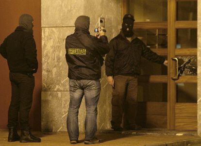 Tres agentes de la Ertzaintza durante un registro en la localidad vizcaína de Ondarroa, dentro de la operación contra ETA que se ha saldado con cinco detenidos.