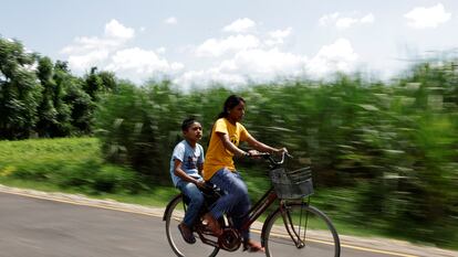 Parwati Sunar, 27, and her son Resham Sunar, 11, ride a bicycle to their computer class at New World Vision Computer Institute in Punarbas, Kanchanpur district, southwest Nepal, August 8, 2022. Parwati attends the same school as her eldest son, Resham, after returning to an education system she fled at the age of 15, when she eloped with a man seven years her senior. Parwaiti said she hoped to become "literate enough"?to be able to keep household accounts. "I think I should not have left my school," she said, explaining the desire to catch up on the lessons she missed. REUTERS/Navesh Chitrakar SEARCH "CHITRAKAR NEPAL EDUCATION" FOR THIS STORY. SEARCH "WIDER IMAGE" FOR ALL STORIES. TPX IMAGES OF THE DAY