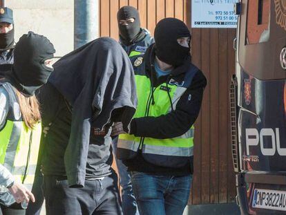 Agentes de la Polic&iacute;a Nacional acompa&ntilde;an a uno de los detenidos en Figueres. 