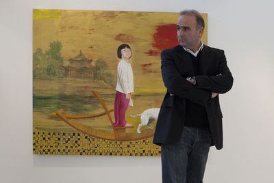 El pintor Juan Vida, junto a una de las obras que expone en Granada.
