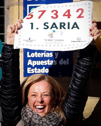 Ainhoa Tais, dueña de una administración de lotería en el centro de San Sebastián, celebra los 400.000 euros que ha repartido del primer premio en el sorteo de El Niño.
