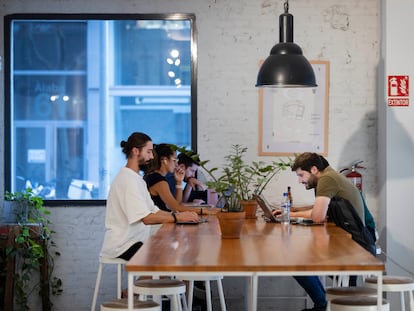 Jóvenes trabajan en la cafetería del espacio de 'coworking' Itnig del barrio del Poblenou de Barcelona.