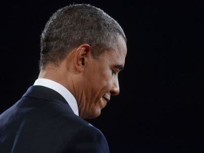 Obama escucha a Romney durante el primer debate presidencial.