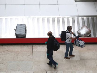 Dos pasajeros recogen su equipaje ayer, 12 de mayo, en el aeropuerto de Madrid-Barajas.
