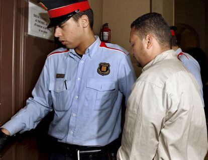 Un agente de los Mossos conduce a un detenido en los juzgados.