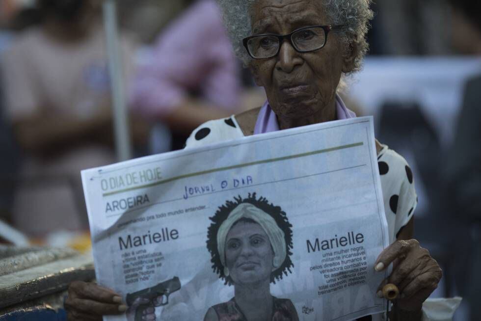Una mujer muestra un periódico con el rostro de Marielle Franco.