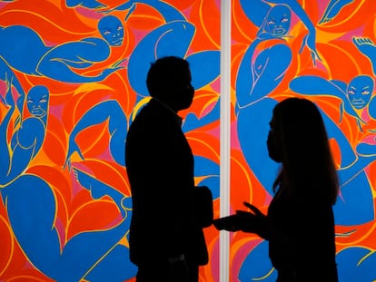 Dos personas caminan frente a un cuadro de Tunji Adeniyi-Jones en la feria Art Basel en Miami Beach, este martes.