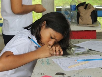 Alumna salvadoreña de primaria escribiendo en la escuela.
