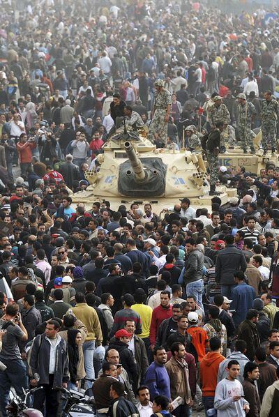 Manifestantes contra el régimen de Mubarak rodean un carro de combate en el Cairo.