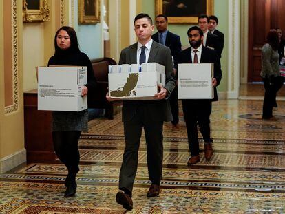 Un grupo de 'staffers' traslada cajas de documentos a la oficina del líder de la minoría del Senado, Chuck Schumer