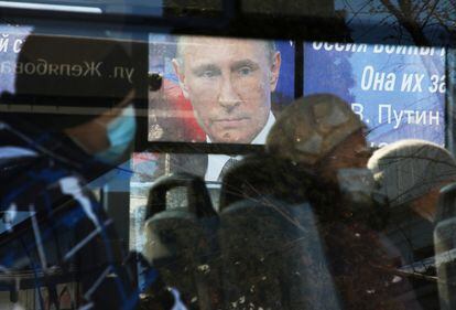 Un autobús pasa ante una pantalla con la imagen de Putin, el viernes en Simferópol, Crimea.