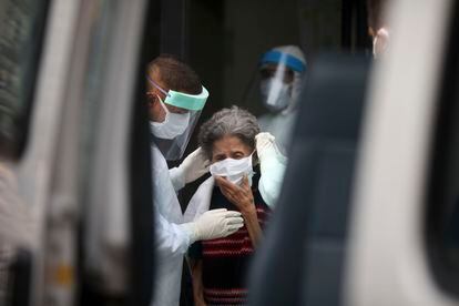 Enfermeros evacúan este miércoles a una anciana de un geriátrico de Buenos Aires donde se ha registrado un brote de covid-19
