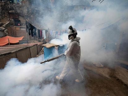 Un integrante de una brigada de salud fumiga una calle para evitar la propagación del dengue en el distrito de San Juan de Lurigancho, en Lima, el pasado 11 de mayo.