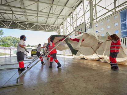 Médicos y voluntarios preparan carpas en las inmediaciones del Instituto de Educación Secundaria de Mendillorri, en Pamplona, para realizar pruebas PCR este jueves.