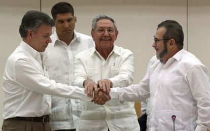 Santos y Timochenko se dan la mano ante Ra&uacute;l Castro. 
