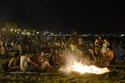 La gente se reúne alrededor de los incendios durante las celebraciones anuales de San Juan, en una playa de Alicante.
