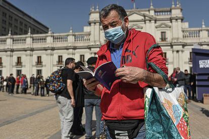 Un hombre lee su copia del borrador, frente al palacio presidencial, este jueves.