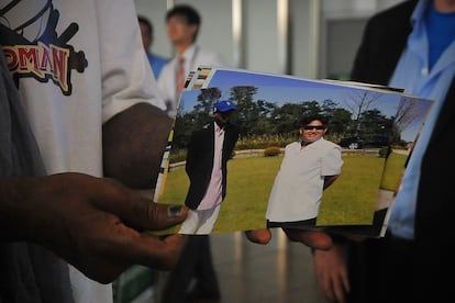 Dennis Rodman muestra una foto suya con Kim Jong-Un en el aeropuerto de Pekín, a su regreso de Corea del Norte en 2013.