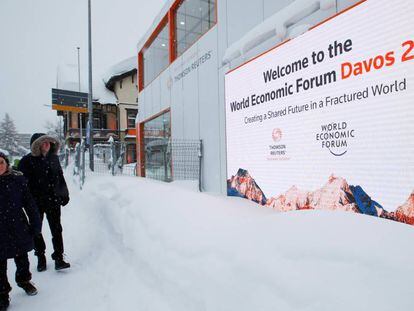 Varias personas pasan ante el centro de convenciones donde se celebra el Foro Económico en Davos.