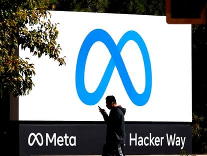 Una persona pasa frente al logo de Meta en la sede central de la compañía, en Menlo Park (California, EE UU).
