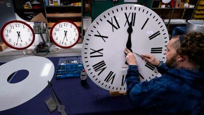 Ian Roders ajusta las manecillas de un reloj en un taller en Medfield, (Massachusetts).