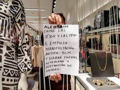 Andrea Pascual, dependienta de la tienda Parfois, muestra el cartel que le ha entregado un desconocido antes de los disturbios.
