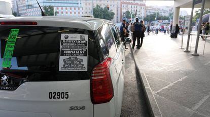 Un taxi en Madrid con uno de los carteles de la huelga de este martes.