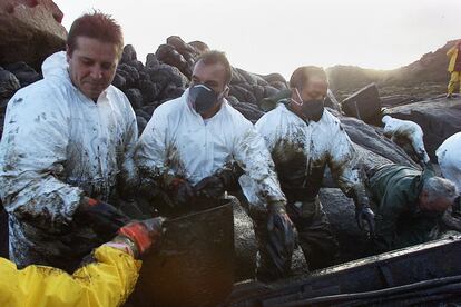 Roberto Castro y Juan José Quiza Carríl durante las labores de limpieza del vertido, en la zona de Pelouro (Costa da Morte). Diciembre 2002.