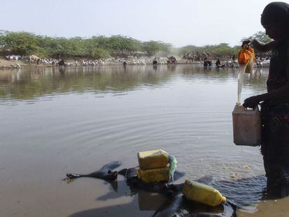 Una mujer etíope recoge agua de un estanque construido para mejorar la resiliencia frente a la sequía.