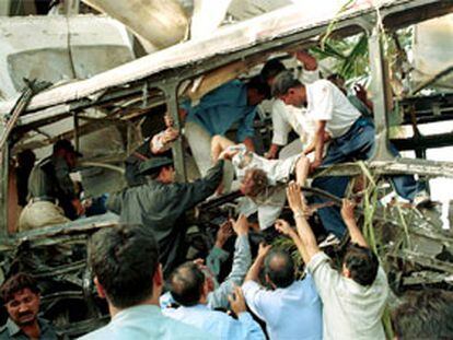 Un grupo de voluntarios traslada uno de los cadáveres de las víctimas del atentado contra un autobús en Karachi.