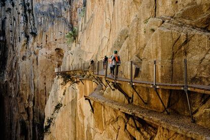 Un grupo atraviesa el desfiladero de El Chorro, en el Caminito del Rey (Málaga).