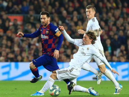 Messi y Modric pugnan por un balón durante el primer clásico de esta temporada.