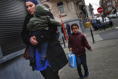 Una mujer camina junto a sus dos hijos por el barrio de Schaerbeek. Los vecinos creen que el hecho de que los yihadistas se alojaran en el barrio es algo "aislado" y recalcan que venían de fuera.