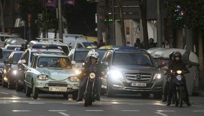 Diversos vehicles esperen en un semàfor del carrer Aragó, a Barcelona.