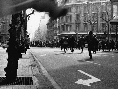 Una de les imatges de la mostra, amb gent corrent davant la policia. 