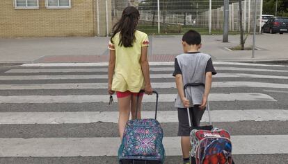 Dos nens surten de l'escola amb les claus de casa a la mà.