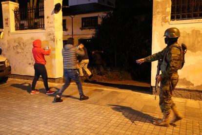 Periodistas graban a policías mientras ingresan en el terreno de la Embajada de México.