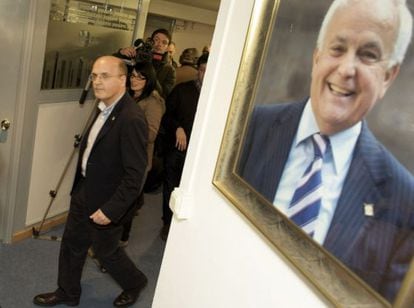 José Manuel Baltar, ayer, pasa ante el retrato de su padre camino al comité de dirección del PP. / N. GÓMEZ