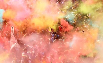 Agentes de los Mossos d'Esquadra y manifestantes en medio de una nube de polvos holi en los altercados de la manifestación de este sábado en Barcelona.