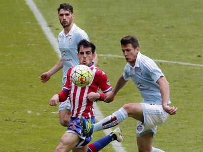 El jugador del Sporting Carlos Castro, y Planas y Radoja, del Celta de Vigo, durante el partido correspondiente a la jornada 32 de la Liga de Primera Divisi&oacute;n